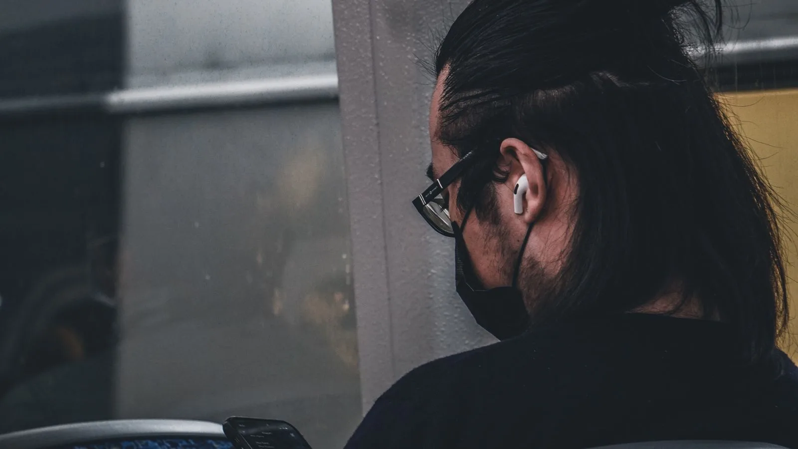 Passenger using a smartphone with earphones while traveling on a bus