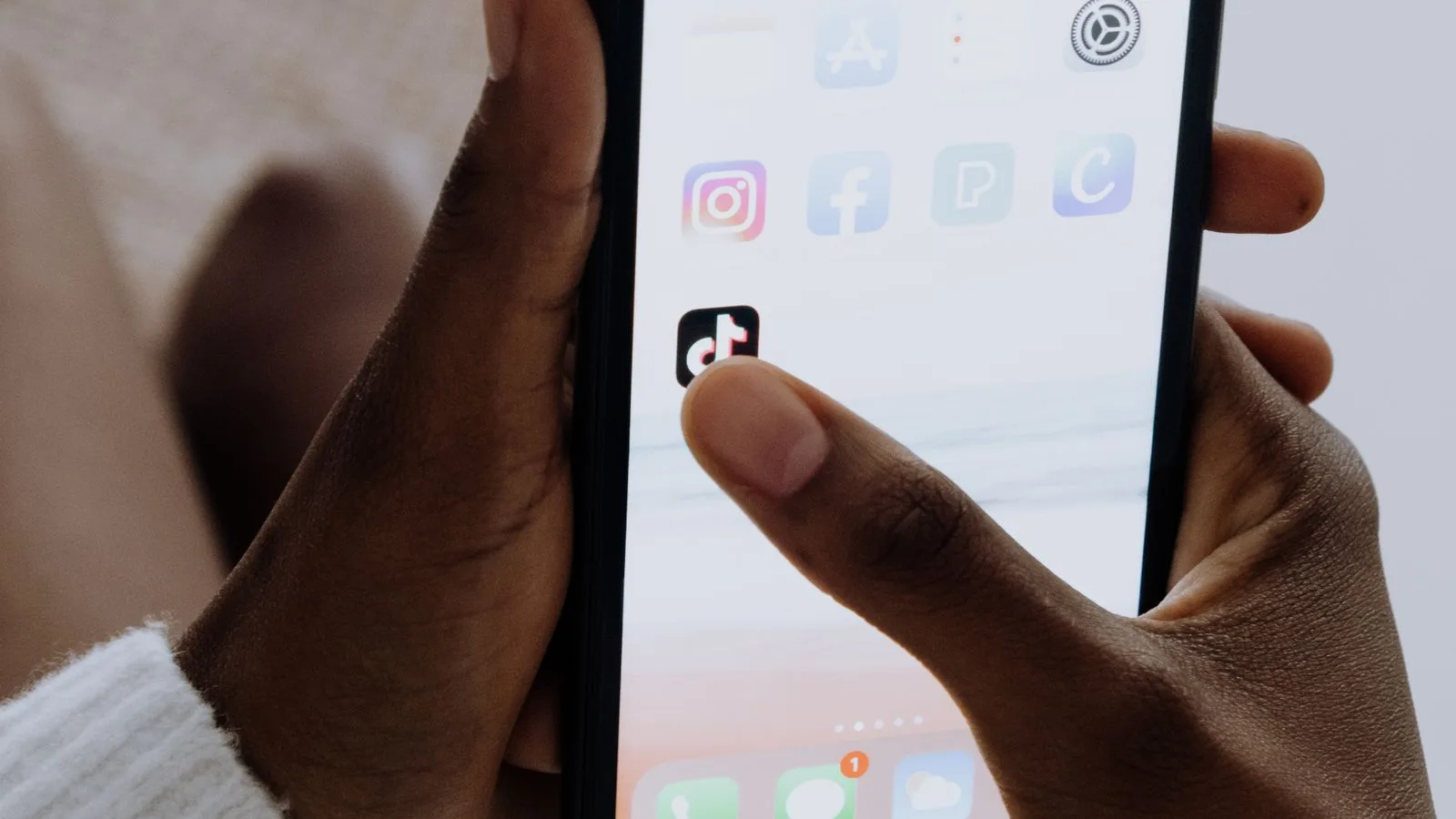 Hands holding a smartphone with social media apps, representing TikTok voice comments and interactive comment tools
